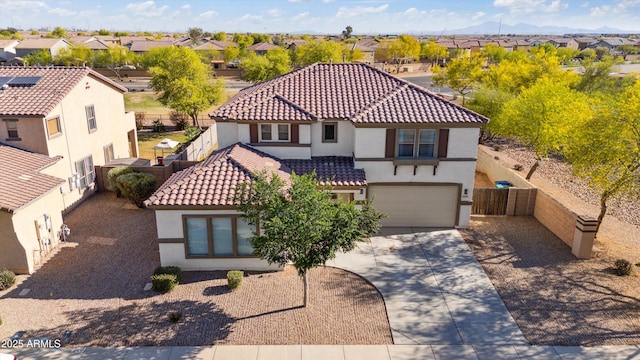 mediterranean / spanish home with concrete driveway, fence, a residential view, and stucco siding
