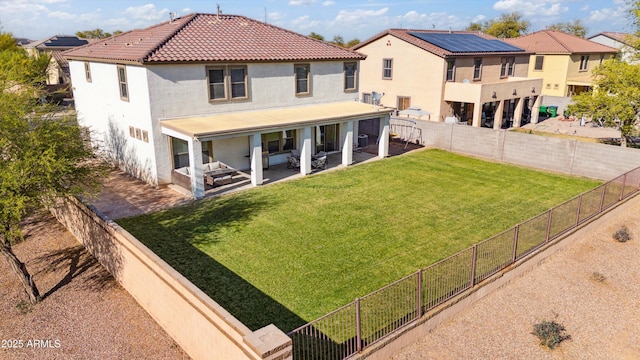 rear view of property featuring a yard, a fenced backyard, a patio, and stucco siding