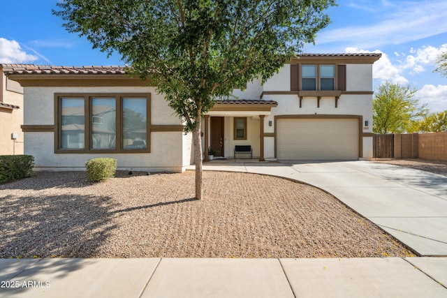 view of front of property featuring concrete driveway, stucco siding, a tiled roof, and an attached garage