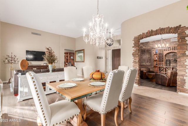 dining space with light hardwood / wood-style flooring and a chandelier