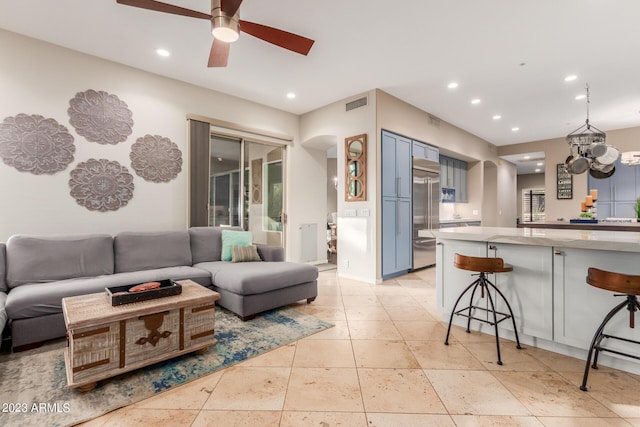 living room featuring ceiling fan with notable chandelier