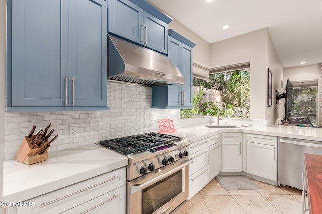 kitchen featuring sink, white cabinetry, stainless steel appliances, light stone countertops, and decorative backsplash