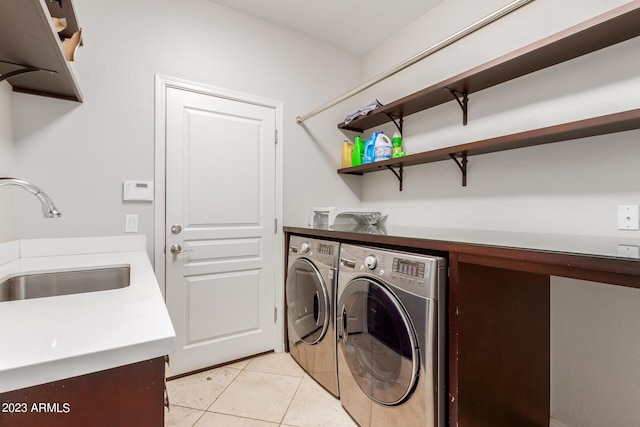 laundry area featuring independent washer and dryer, sink, and light tile patterned floors