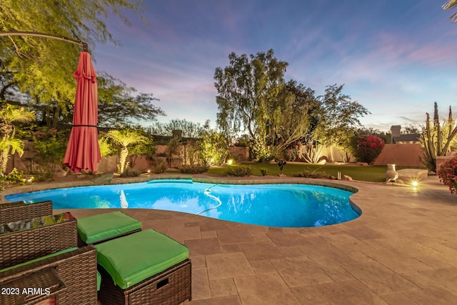 pool at dusk with a patio