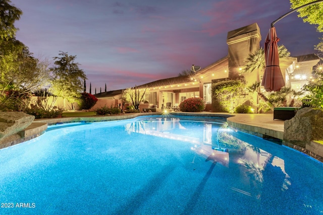 pool at dusk with a wooden deck