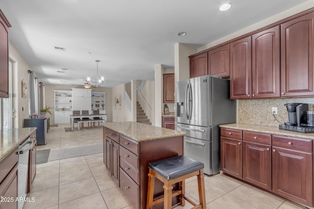 27053 N 172nd Ln, Surprise, AZ 85387 - kitchen with stainless steel appliances, light stone counters, a kitchen island, decorative backsplash, and recessed lighting