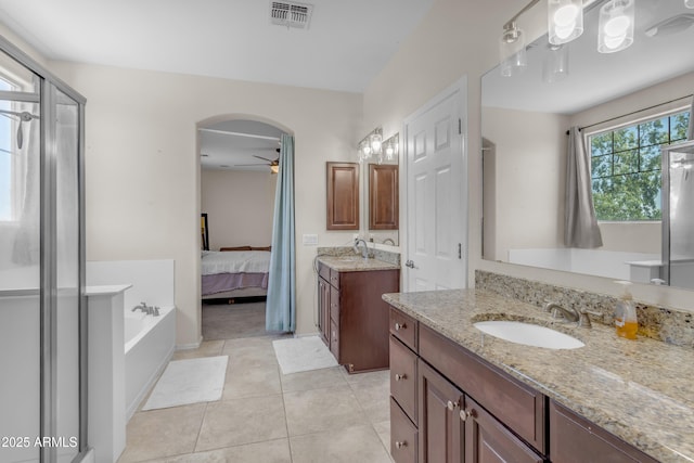 27053 N 172nd Ln, Surprise, AZ 85387 - ensuite bathroom featuring a ceiling fan, two vanities, tile patterned floors, and a garden tub