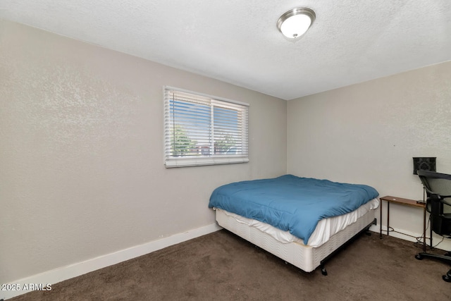 carpeted bedroom featuring baseboards and a textured ceiling