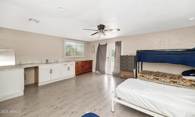 bedroom featuring a sink, access to exterior, a ceiling fan, light wood-type flooring, and visible vents