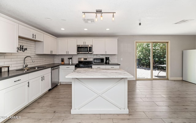 kitchen featuring a sink, tasteful backsplash, stainless steel appliances, and visible vents