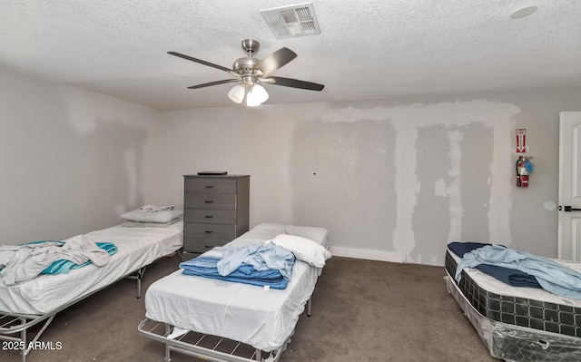 carpeted bedroom featuring a ceiling fan, a textured ceiling, visible vents, and baseboards