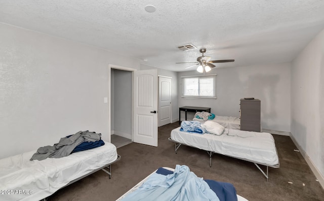 carpeted bedroom with a ceiling fan, a textured ceiling, visible vents, and baseboards