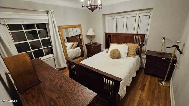 bedroom featuring dark hardwood / wood-style floors and an inviting chandelier