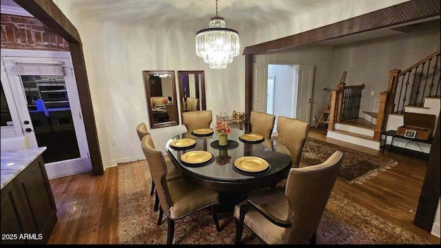 dining space with dark hardwood / wood-style flooring and an inviting chandelier