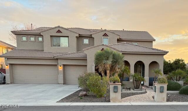 mediterranean / spanish home with a garage