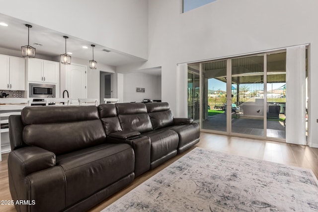 living room with a high ceiling and light wood-type flooring