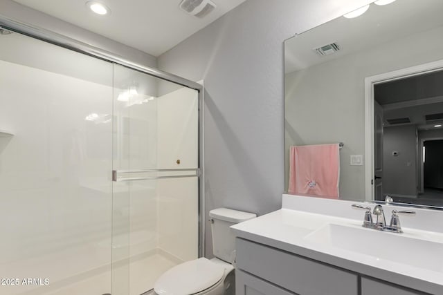 bathroom with toilet, vanity, and walk in shower