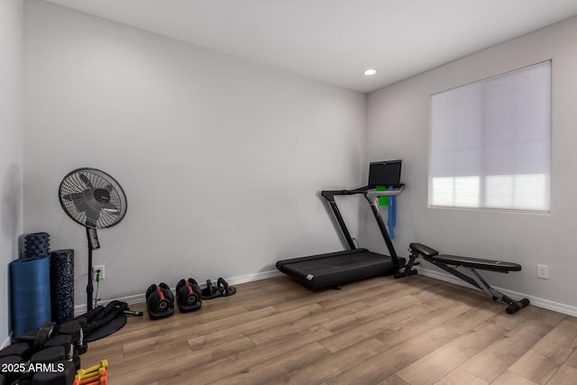 exercise room with light hardwood / wood-style floors