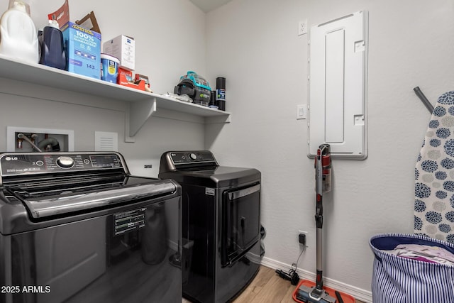 laundry room featuring hardwood / wood-style floors, electric panel, and independent washer and dryer