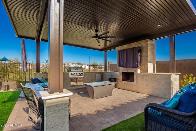 view of patio / terrace with exterior kitchen, ceiling fan, grilling area, and exterior fireplace