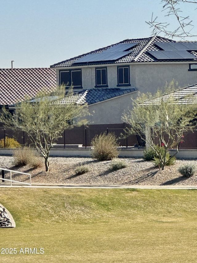 view of front of property featuring solar panels