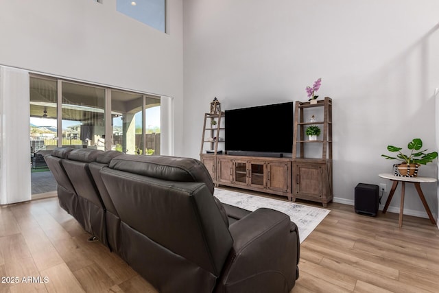 living room with a high ceiling and light wood-type flooring