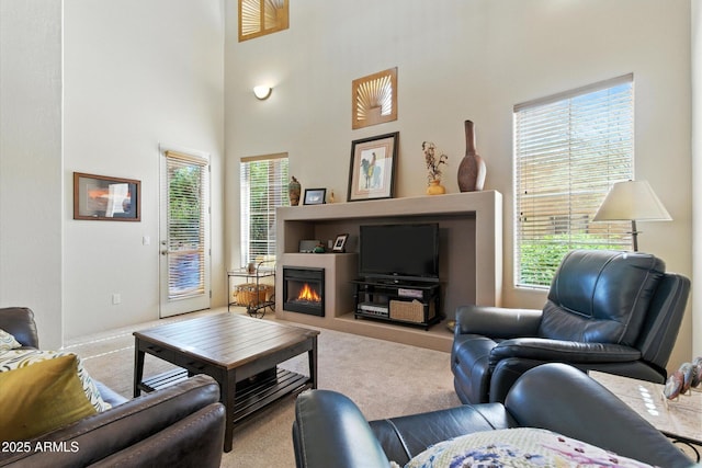 5370 S Desert Dawn Dr Unit 56, Gold Canyon, AZ 85118 - living area featuring carpet flooring, healthy amount of natural light, a lit fireplace, and a towering ceiling
