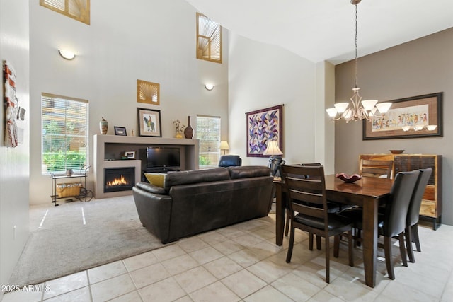5370 S Desert Dawn Dr Unit 56, Gold Canyon, AZ 85118 - dining space with a chandelier, high vaulted ceiling, light colored carpet, light tile patterned flooring, and a lit fireplace