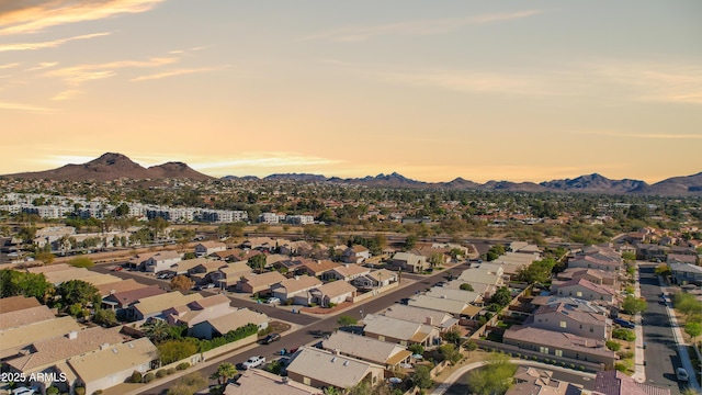 aerial view at dusk featuring a mountain view and a residential view