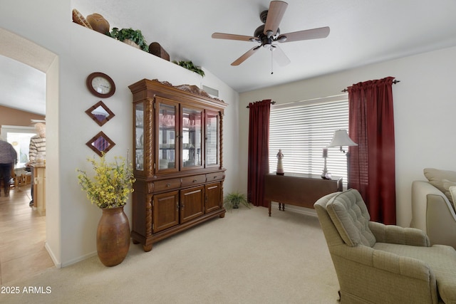 sitting room with baseboards, light colored carpet, a ceiling fan, and vaulted ceiling