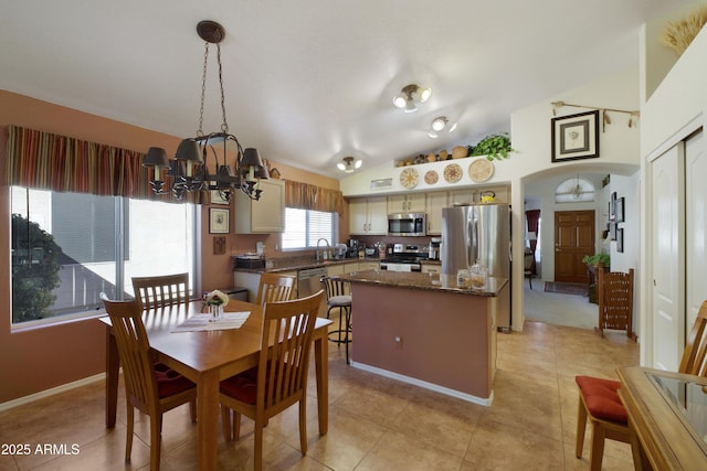 dining room with light tile patterned floors, baseboards, a notable chandelier, and vaulted ceiling