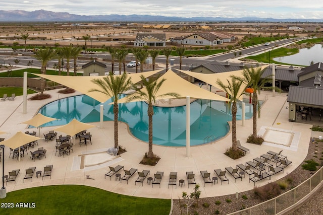view of pool featuring a mountain view, a residential view, a patio area, and fence