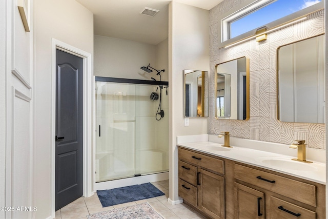 bathroom featuring visible vents, a sink, and a shower stall