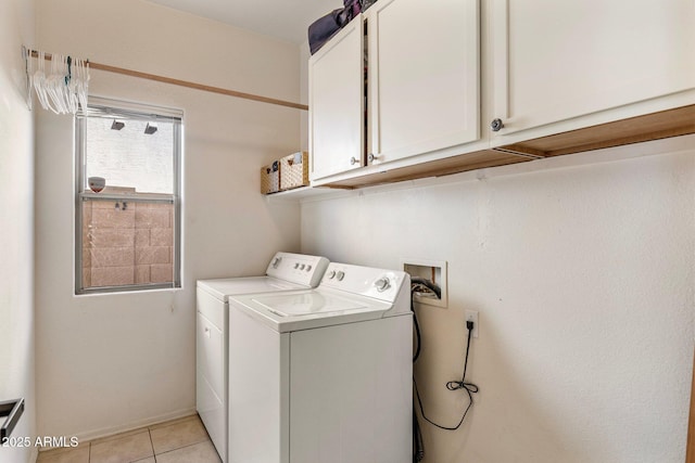 laundry area with light tile patterned floors, washing machine and dryer, and cabinet space