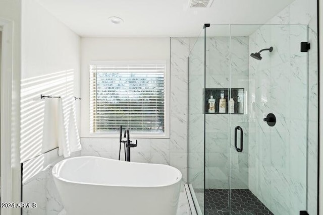 full bath with a marble finish shower, visible vents, and a freestanding tub