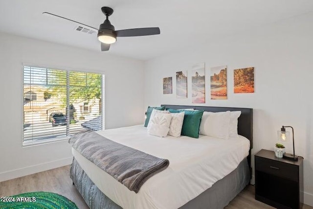 bedroom with ceiling fan, visible vents, baseboards, and light wood-style flooring