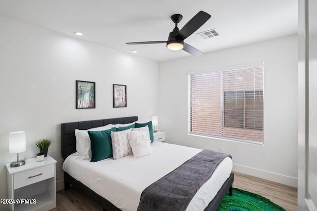 bedroom with a ceiling fan, visible vents, wood finished floors, baseboards, and recessed lighting