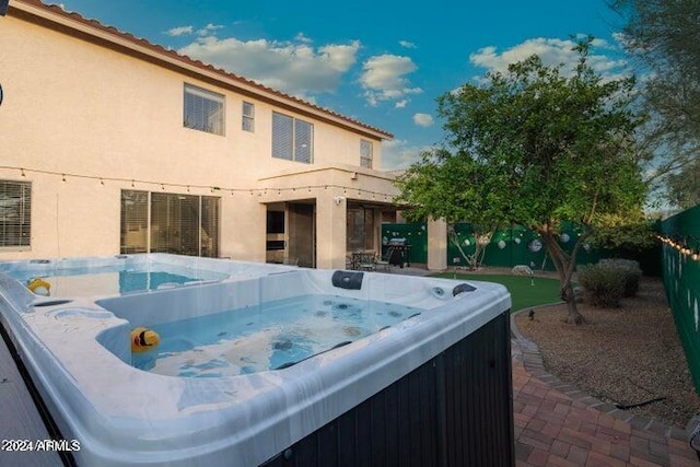 view of swimming pool featuring a fenced backyard and a hot tub