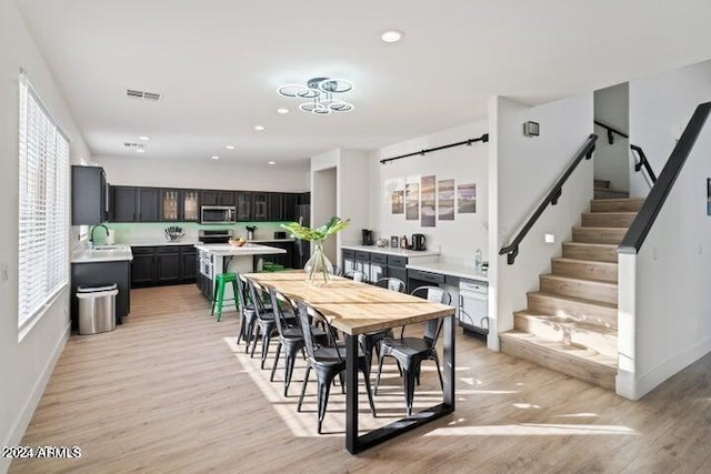 dining area featuring visible vents, recessed lighting, light wood finished floors, baseboards, and stairs