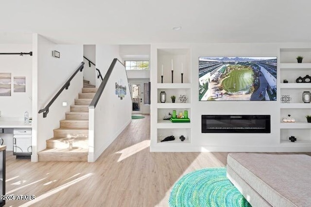 interior space with stairway, built in shelves, and wood finished floors