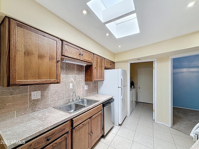 1553 E Flower Cir, Mesa, AZ 85204 - kitchen with dishwasher, a skylight, a sink, light tile patterned flooring, and brown cabinets