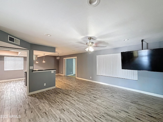 1553 E Flower Cir, Mesa, AZ 85204 - unfurnished living room with light wood-type flooring, baseboards, ceiling fan, and recessed lighting