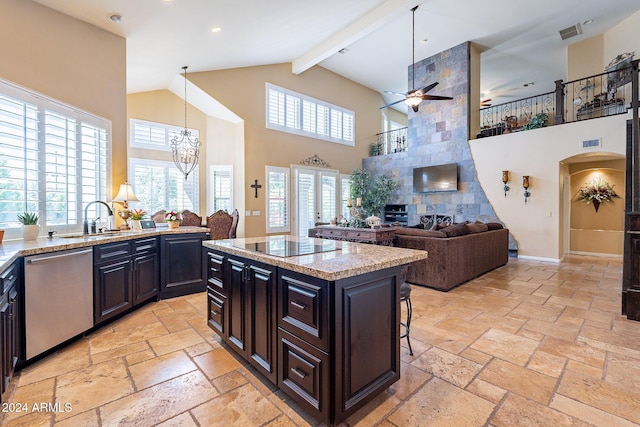 kitchen featuring a towering ceiling, stainless steel dishwasher, pendant lighting, a center island, and a breakfast bar area