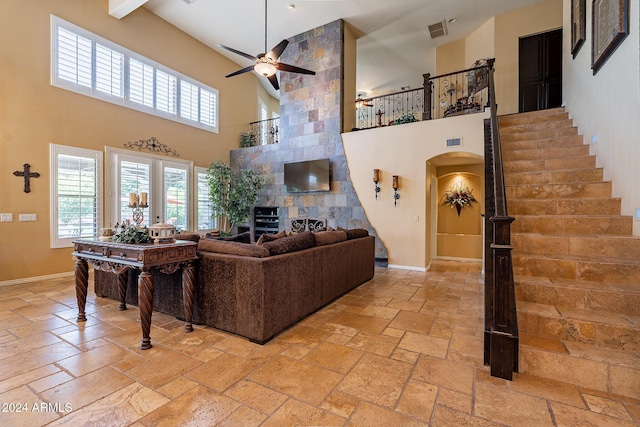 living room with ceiling fan, french doors, and a towering ceiling