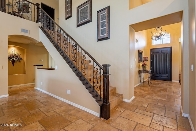 foyer featuring a towering ceiling and a notable chandelier