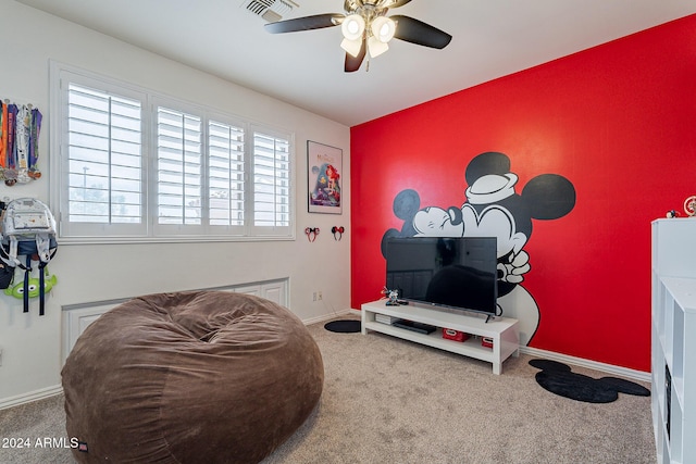 living area featuring carpet flooring and ceiling fan