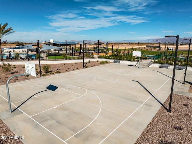 view of basketball court featuring community basketball court, a mountain view, and fence