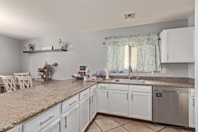 kitchen with light tile patterned floors, dishwasher, sink, and white cabinets