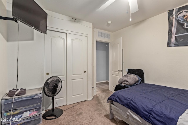 carpeted bedroom featuring ceiling fan and a closet