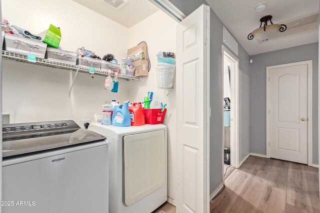 washroom with washing machine and dryer and light wood-type flooring